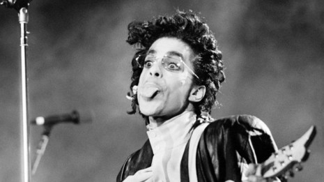 This black and white photo taken on June 17, 1987 shows musician Prince performing onstage during his concert at the Bercy venue in Paris. Pop icon Prince -- whose pioneering brand of danceable funk made him one of music's most influential figures -- died Thursday at his compound in Minnesota. He was 57. The announcement came just a week after the Grammy and Oscar winner was taken to hospital with a bad bout of influenza, although he made light of his health problems after the scare. / AFP PHOTO / Bertrand GUAY
